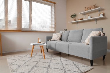 Kanepesi, masası ve rafları olan şık bir oturma odası.