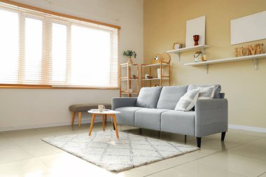 Kanepesi, masası ve rafları olan şık bir oturma odası.