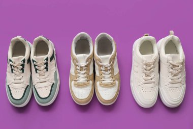 Mor arka planda farklı şık spor ayakkabılar.