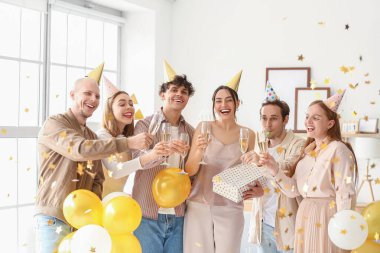 Şampanyalı bir grup genç arkadaş evde doğum gününü kutluyor.