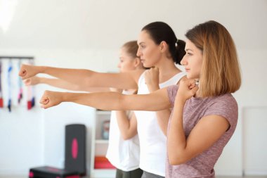 Young women training at self defense courses in gym clipart
