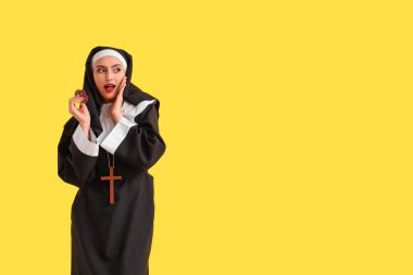 Sarı arka planda poker fişleri olan süpriz bir rahibe.