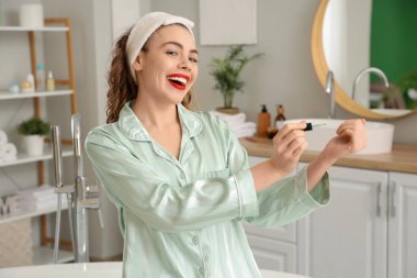 Güzel genç bayan banyoda manikür yapıyor.