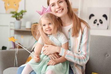 Annesi evde sarılırken peri gibi giyinmiş şirin küçük kız.