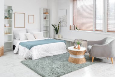 Büyük yataklı, raf üniteli ve çerçeveli aydınlık yatak odasının içi