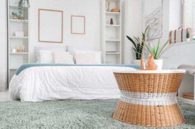 Büyük yataklı, raflı ve masalı hafif yatak odasının içi.