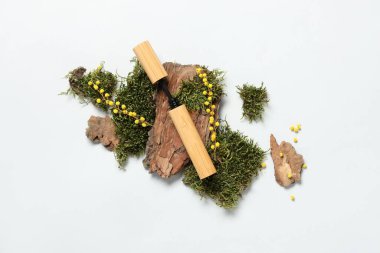 Ağaç kabuğu, yosun ve beyaz arka planda çiçekler olan maskaralar. Eko biçimi kavramı