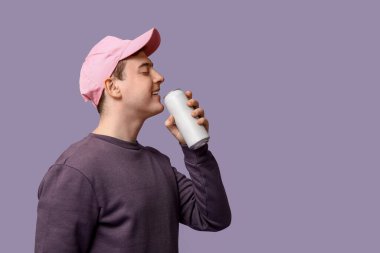 Leylak arka planında soda kutusuyla şapkalı genç bir adam.