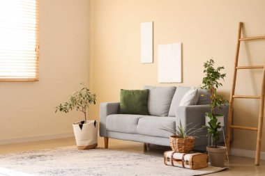 Yastıklı rahat kanepe, ev çiçekleri ve şık oturma odasında merdiven.