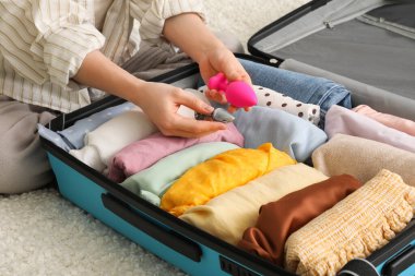 Kadın yatakta otururken bavuluna anal tıkaçlar yerleştiriyor.