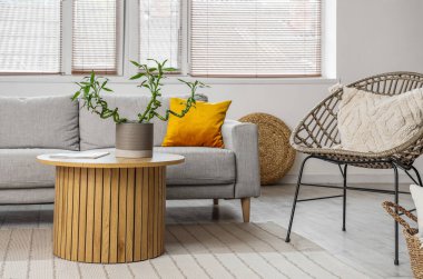 Oturma odasının içinde kahve masası ve kanepenin üzerinde bambu sapları var.