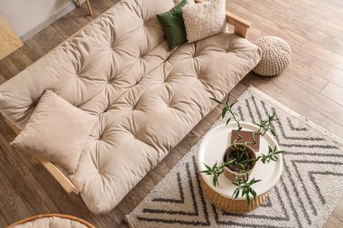 Kahve masası, yastıklar ve beyaz kanepe üzerinde bambu sapları olan hafif oturma odasının şık bir iç mekanı.