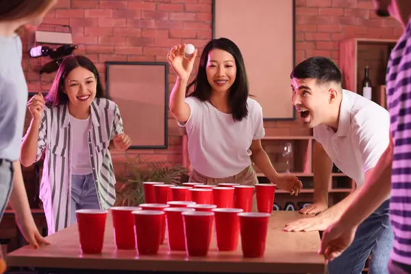 Bir grup genç arkadaş partide bira pong oynuyorlar.