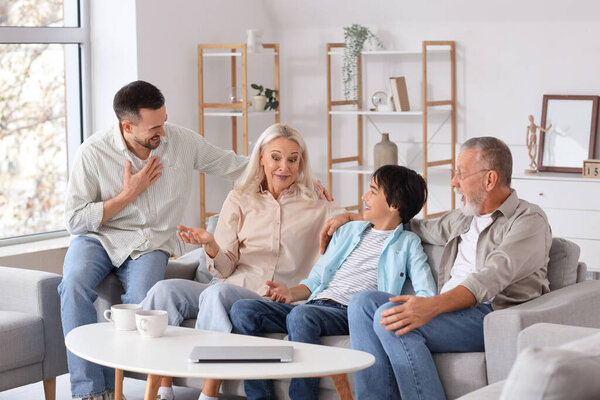 Little boy with his family sitting on sofa at home