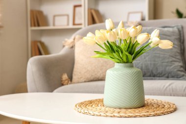 Süslü oturma odasında vazo dolusu lale olan kahve masası.