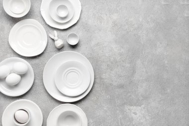 Paskalya yumurtaları ve gri grunge arka planda oyuncak tavşanlı masa ayarı