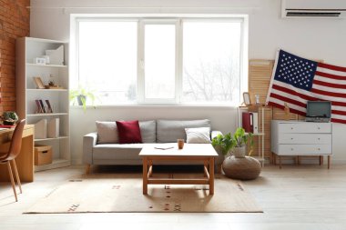Kanepe, raf üniteleri ve ABD bayraklı modern ofis.