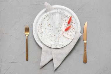 Gri arkaplanda altın çatal bıçak seti olan güzel bir masa.