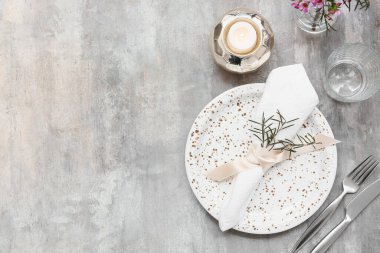 Gri arkaplanda yanan mum ve biberiyeli güzel masa ayarları
