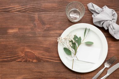 Çingene çiçekleri ve ahşap arka planda yaprakları olan güzel bir masa.