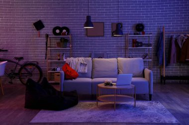 Geceleri kanepesi ve masası olan bir öğrenci odası.