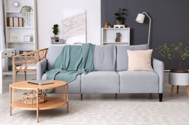 Rahat kanepesi, sehpası ve battaniyesi olan bir oturma odası.