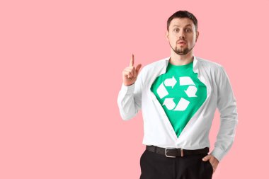 Sarı arka planda geri dönüşüm işareti olan tişörtlü genç adam şaşırdı. Ekoloji kavramı