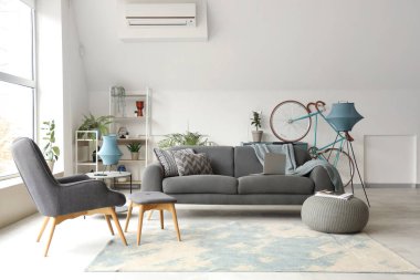 Siyah kanepesi ve koltuğu olan beyaz oturma odasının şık bir iç mekanı.