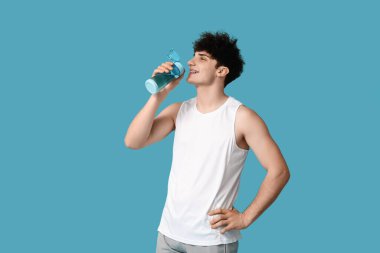 Mavi arka planda su içen sporcu.