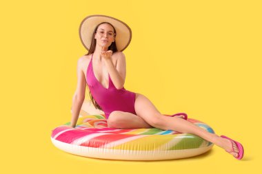 Bikinili gülümseyen kadın ve sarı arka planda şapkalı öpücük.