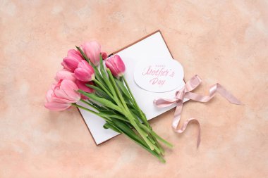 Mesajlı tebrik kartı Mutlu Anneler Günü, güzel pembe laleler ve bej arka planda not defteri