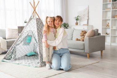 Dadı ve küçük kız evde sarılıyor.