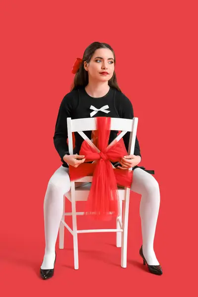 Wanita Muda Bergaya Dengan Busur Duduk Kursi Dengan Latar Belakang Stok Gambar Bebas Royalti