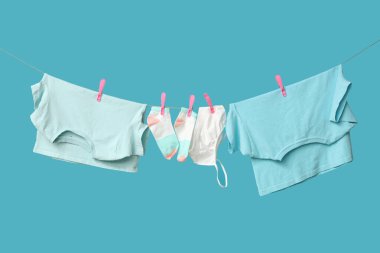 Mavi arka planda ipte asılı elbiseler