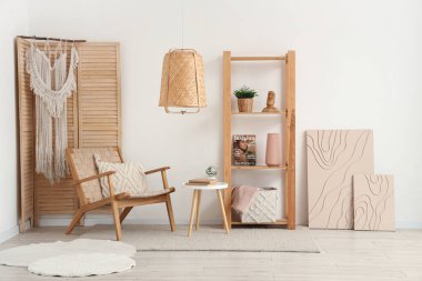 Beyaz oturma odasının içinde rahat koltuğu, sehpası ve raf ünitesi var.