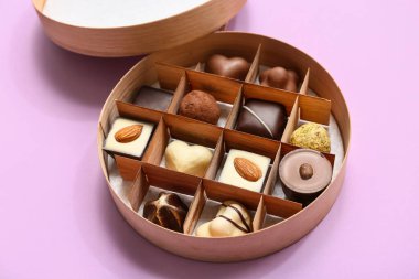 Lezzetli çikolata şekerli bir kutu leylak arka planda, yakın plan.