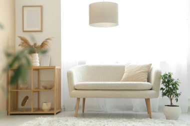 Kanepesi, raf ünitesi ve ışık perdeleri olan şık bir oturma odası.