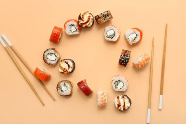 Lezzetli suşi ruloları ve bej arka planda çubuklardan yapılmış çerçeve.