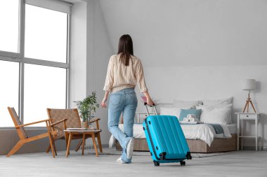 Bavullu kadın, pasaport ve biletler açık otel odasında, arka manzara