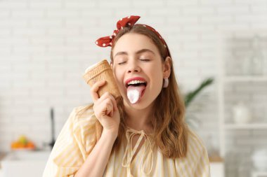 Evde vanilyalı dondurmayı gözleme kabında yalayan genç bir kadın.