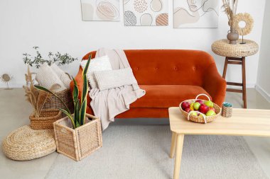 Işıl ışıl oturma odasının içinde rahat bir kanepe, resimler ve kahve masası.