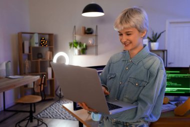 Geceleri bilgisayarla çalışan kadın programcı.
