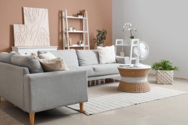 Oturma odasının içinde sehpanın üzerinde modern elektrikli vantilatör var.