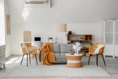 Modern elektrikli fanı sehpada olan şık bir oturma odası.