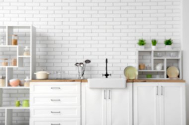 Lavabosu, beyaz tezgahı ve raf ünitesi olan şık bir mutfak, bulanık bir manzara.