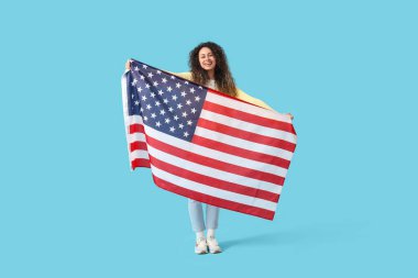 Mavi arka planda Amerikan bayrağı olan genç bir Afro-Amerikalı kadın.