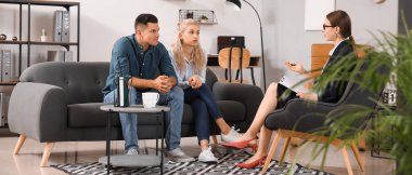 Ofiste genç bir çiftle çalışan psikolog.