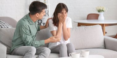 Genç adam karısıyla kavga üstüne kavga etmeye çalışıyor.  