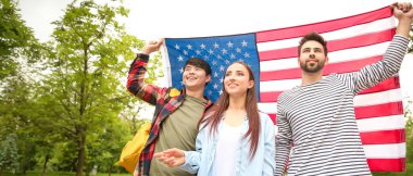 Açık havada ABD bayrağı taşıyan bir grup genç