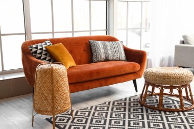 Oturma odasının içinde kırmızı kanepe, lamba ve masa.